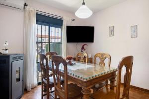 a dining room with a table and chairs and a television at Casa Mia Jacuzzi Exterior in Ronda
