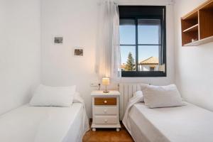 two beds in a small room with a window at Casa Mia Jacuzzi Exterior in Ronda