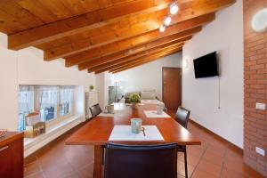 a dining room with a wooden table and chairs at La Corte Di Zio Pippo in Albavilla