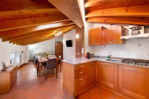 a kitchen with wooden cabinets and a dining table at La Corte Di Zio Pippo in Albavilla