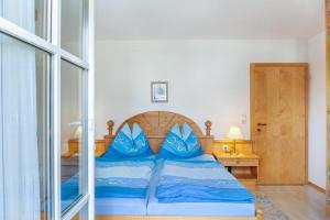 a bedroom with a bed with blue pillows on it at Landhaus Sonja 1 in Leutasch