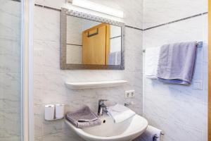 a white bathroom with a sink and a mirror at Landhaus Sonja 1 in Leutasch +17 photos