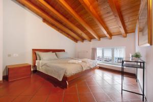 a bedroom with a bed and a wooden ceiling at La Corte Di Zio Pippo in Albavilla