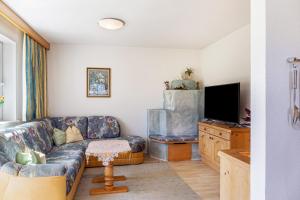 a living room with a couch and a flat screen tv at Landhaus Sonja 1 in Leutasch