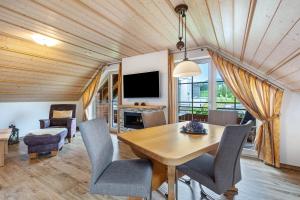 a dining room with a table and chairs and a television at Cafe-Restaurant-Gästehaus Waldvogel in Feldberg