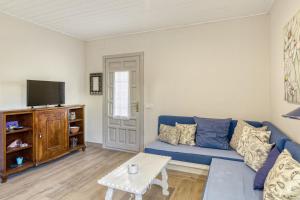 a living room with a blue couch and a tv at Apartamento Bajo 2 in Begur