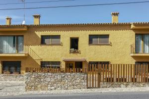 a yellow brick house with a stone wall at Apartamento Bajo 2 in Begur