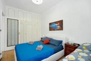 a bedroom with a blue bed with two shoes on it at Casa Dica in Rapallo