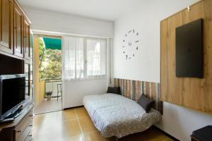 a bedroom with a bed and a tv and a window at Casa Dica in Rapallo
