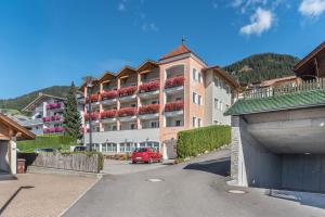 a red car parked in front of a large building at Residence Diana Apartment 401 in Terento