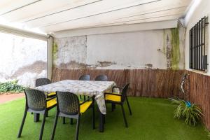 a table and chairs on a patio with grass at Alojamiento cerca de Puy de Fou in Manzaneque