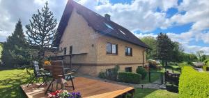a small house with a wooden deck in front of it at Ferienwohnung Zum Plauderbaum in Balve