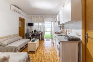 a kitchen and living room with a couch and a table at Alojamiento cerca de Puy de Fou in Manzaneque