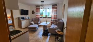 a kitchen with a living room with a table and chairs at Ferienwohnung Zum Plauderbaum in Balve