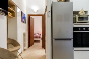 a kitchen with a refrigerator and a microwave at Appartamento Onda d'argento in Porto Santo Stefano