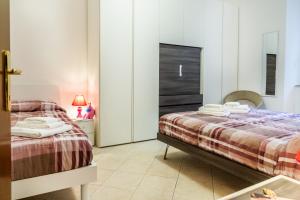 a bedroom with two beds and a mirror at Appartamento Onda d'argento in Porto Santo Stefano