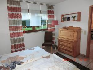 a bedroom with a bed and a dresser and a window at Ferienwohnung Zum Plauderbaum in Balve