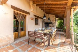 a dining room with a table and chairs on a patio at Dalt La Figuera in La Higuera