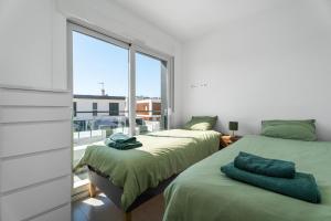 two beds in a room with a large window at Casa Bos Palm Tree Villa with Pool in Gran Alacant +23 photos