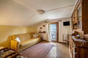 a living room with a couch and a television at La Mansarda di Chiara e Silvio in Trasquera