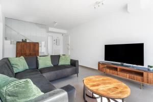 a living room with a couch and a flat screen tv at Casa Bos Palm Tree Villa with Pool in Gran Alacant