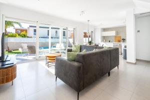 a living room with a couch and a table at Casa Bos Palm Tree Villa with Pool in Gran Alacant