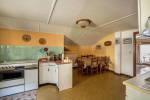 a kitchen with white appliances and a dining room at La Mansarda di Chiara e Silvio in Trasquera +13 photos