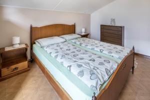 a bedroom with a large bed and a dresser at La Mansarda di Chiara e Silvio in Trasquera