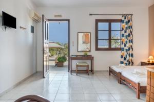 a living room with a table and a room with a window at Frantzis Studio 6 Nisyros Island in Páloi