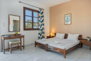 a bedroom with a bed and a table and a mirror at Frantzis Studio 6 Nisyros Island in Páloi