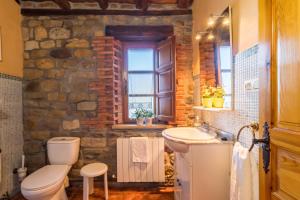 a stone walled bathroom with a toilet and a sink at Apartamento Juntana 2 in Villacarriedo +21 photos