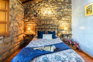 a bed in a room with a stone wall at Apartamento Juntana 2 in Villacarriedo