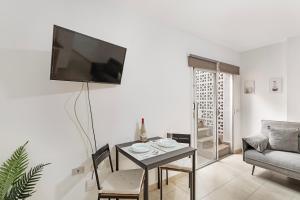 a living room with a table and a tv on a wall at Apartamento Danoe 3 in Mogán