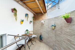 a patio with a table and chairs and plants on the wall at Apartamento Danoe 3 in Mogán