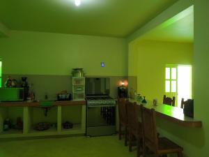 a kitchen with green walls and a counter with chairs at Tranquilidad y comodidad in Dolores Hidalgo