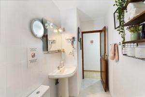 a white bathroom with a sink and a mirror at Apartamento Danoe 3 in Mogán