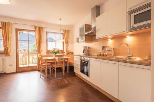 a kitchen with a table and a dining room at Tischlerhof - Typ B mit Terrasse in Tirolo