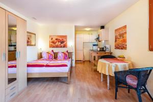 a bedroom with a bed and a table and a kitchen at Hach in Sulzburg