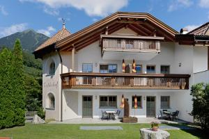a large house with a balcony and a deck at Tischlerhof - Typ B mit Terrasse in Tirolo