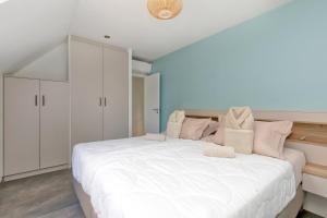 a bedroom with a large white bed with pink pillows at Villa Ker Minet - Hoedic - 6 pers in Piriac-sur-Mer +9 photos