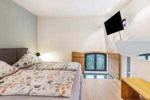a bedroom with a bed and a flat screen tv at Die Ferienwohnung in Reichenau