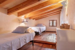 two beds in a room with wooden ceilings at Finca Ca'n Vaqueta in Sóller +17 photos