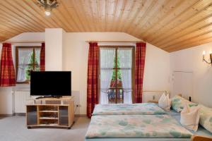 a bedroom with two beds and a flat screen tv at Ferienwohnung Frieder in Grainau