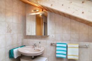 a bathroom with a sink and a mirror and towels at Ferienwohnung Frieder in Grainau +16 photos