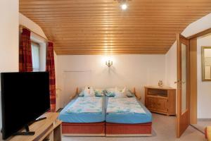 a bedroom with a bed and a flat screen tv at Ferienwohnung Frieder in Grainau