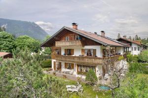 a large wooden house in the middle of a field at Ferienwohnung Frieder in Grainau