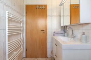 a bathroom with a sink and a wooden door at Auszeit an der Eider in Hennstedt +21 photos