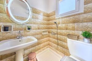 a bathroom with a sink and a toilet and a mirror at Dolphin villa 1 in Gaios +26 photos