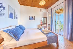 a bedroom with a large bed with blue pillows at Dolphin villa 1 in Gaios