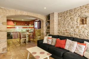 a living room with a black couch and a kitchen at Casa Vermella in Orriols